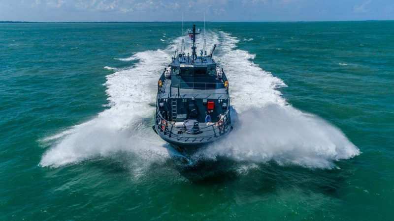 Aerial head-on view of a 35 metre fast security vessel at speed throwing a bow wave — industrial photographer Singapore, aerial marine, drone maritime photography