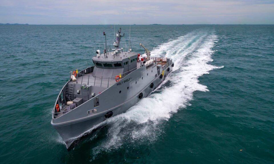 Aerial quarter view of a grey 35 metre fast security vessel by Sam Aluminium Engineering under way at speed, aerial marine photography in Singapore; vessel drone photography