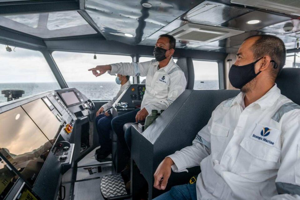 Two marine engineers in the wheelhouse of a new build during a Singapore sea trial — Singapore industrial photography, men at work