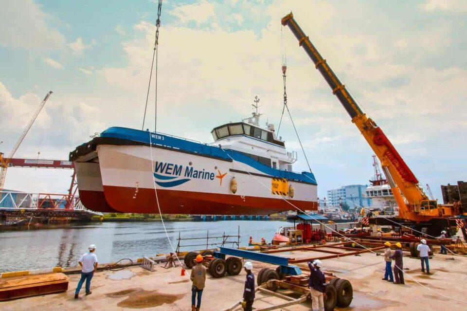WEM Marine hull on the slipway with a crawler crane and yard team during a boat launch — industrial photographer Singapore, shipyard photography