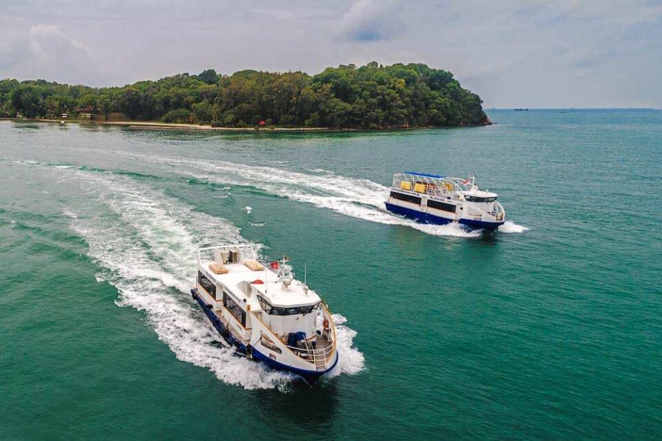 Aerial view of passenger craft under way past a wooded island in Singapore waters — aerial photography Singapore, marine photography, marine drone photography