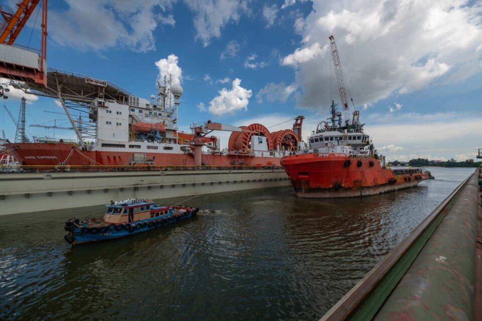 Shipyard with an offshore supply vessel and workboats alongside the repair berth — Singapore industrial photographer, shipyard photography