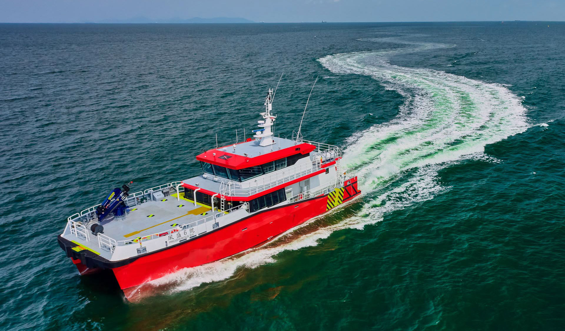 Brevity-class crew transfer vessel turning at speed at a Singapore anchorage, Singapore aerial vessel photography by drone