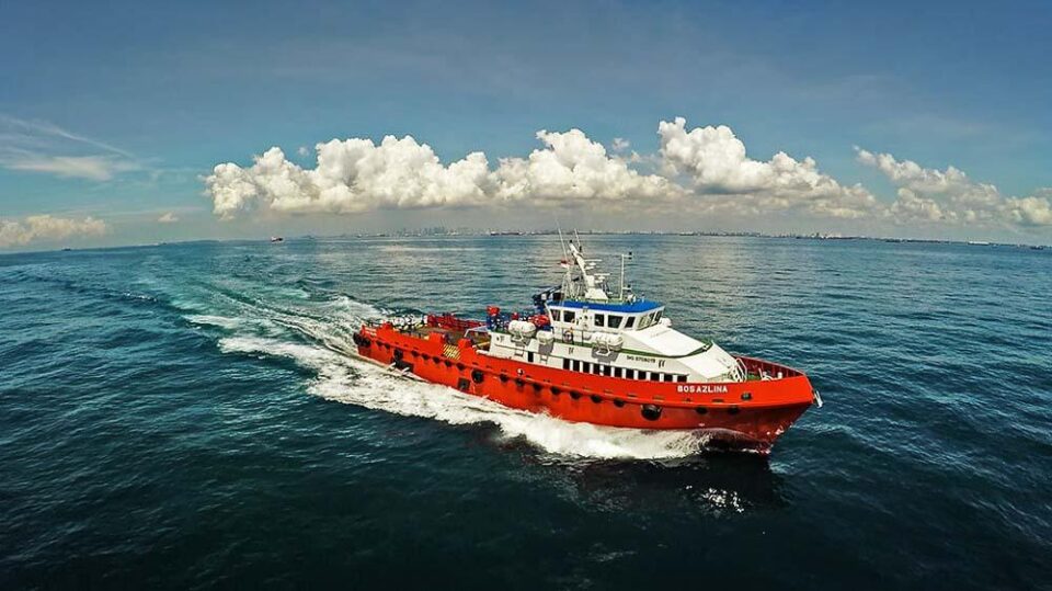 Offshore support vessel Bos Azlina on sea trials in open water under a full cloud bank — aerial drone photography of a vessel on sea trials