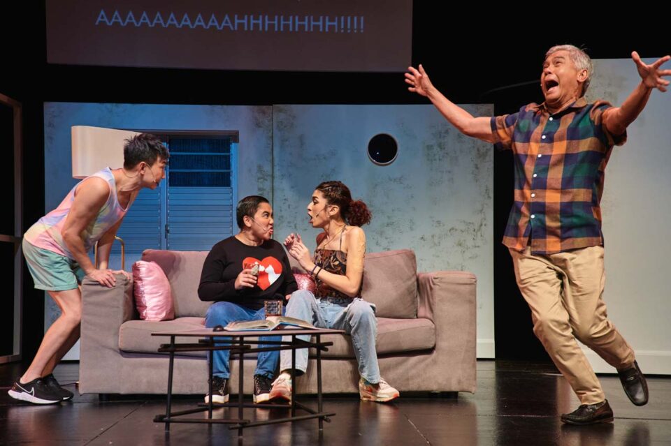 Singapore theatre photography: production photography. An actor flings his arms wide at the peak of an outburst while the three on the sofa react in the same instant, in Old Gaze