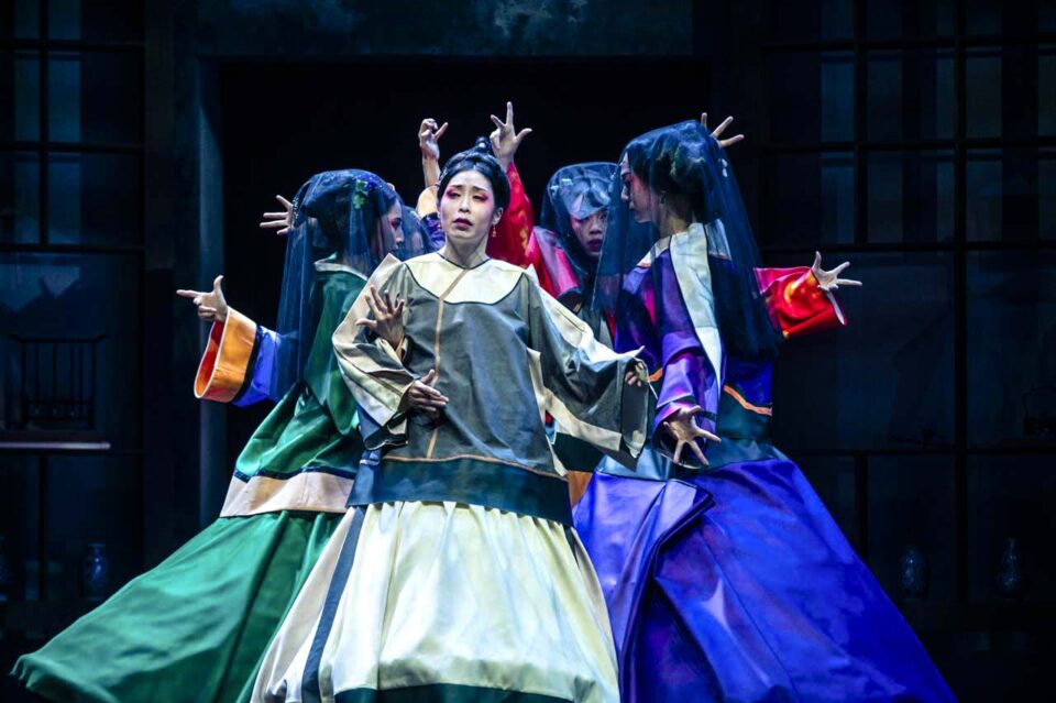 Singapore theatre photography: production photography. Chinese opera performers in flowing robes and veils raise their hands around a central figure, in The Crab Flower Club
